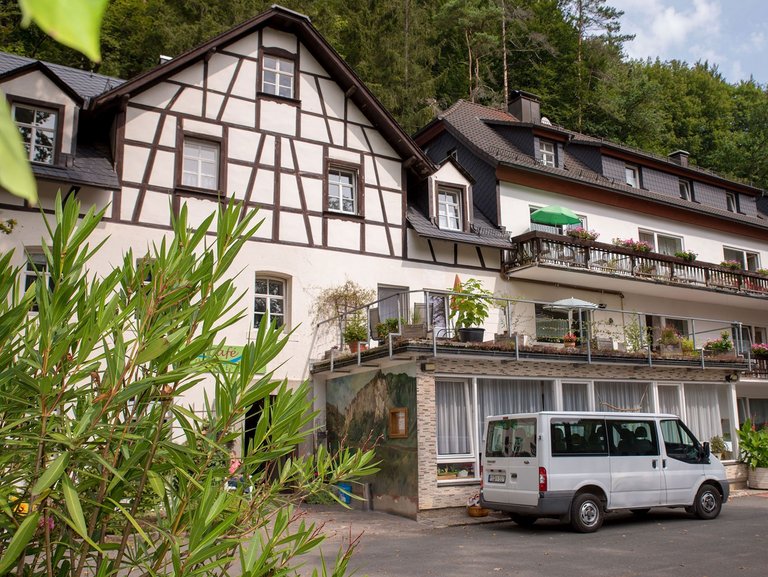 vor der Suchthilfe (Fachwerkhaus) steht ein Transporter - zu sehen sind auch einige Balkone mit vielen Blumen